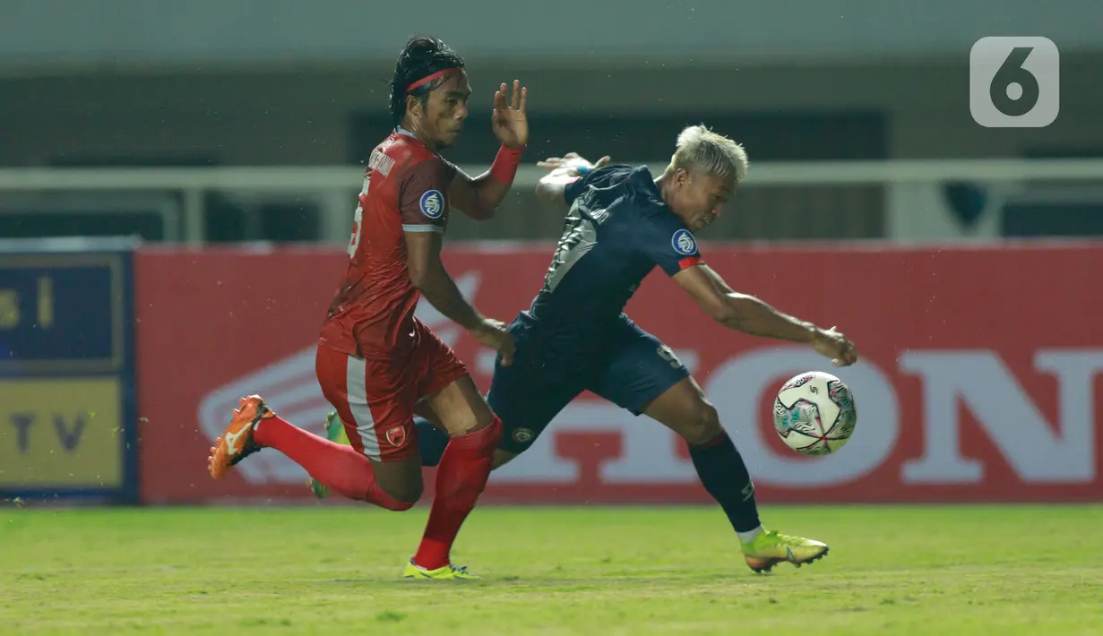 Pemain Arema FC, Kushedya Hari Yudo, berebut bola dengan pemain PSM Makassar, Erwin Gutawa pada pertandingan BRI Liga 1 2021 di Stadion Pakansari, Bogor, Minggu (5/9/2021). PSM Makassar bermain imbang atas Arema FC 1-1. (Bola.com/M Iqbal Ichsan)