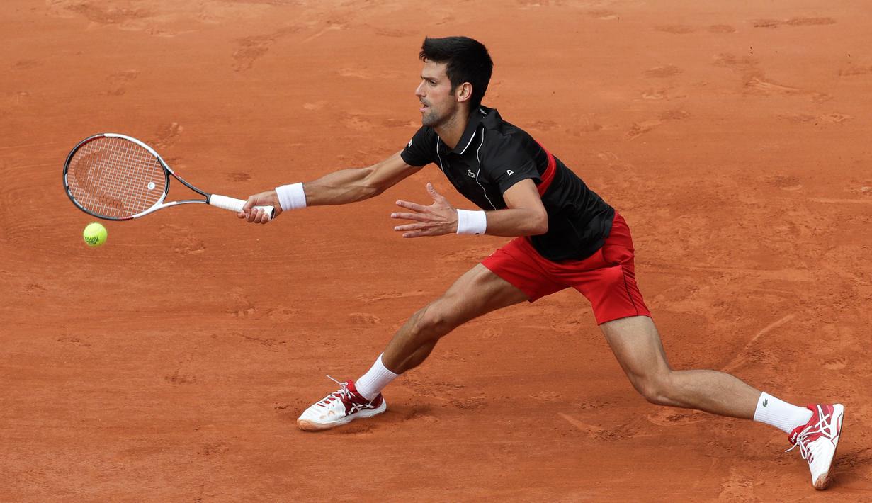 Petenis Serbia, Novak Djokovic melakukan servis ke arah petenis Italia Marco Cecchinato pada perempatfinal Prancis Terbuka 2018 di stadion Roland Garros, Selasa (5/6). Djokovic tumbang 3-6, 6-7, 6-1, dan 6-7. (AP/Alessandra Tarantino)