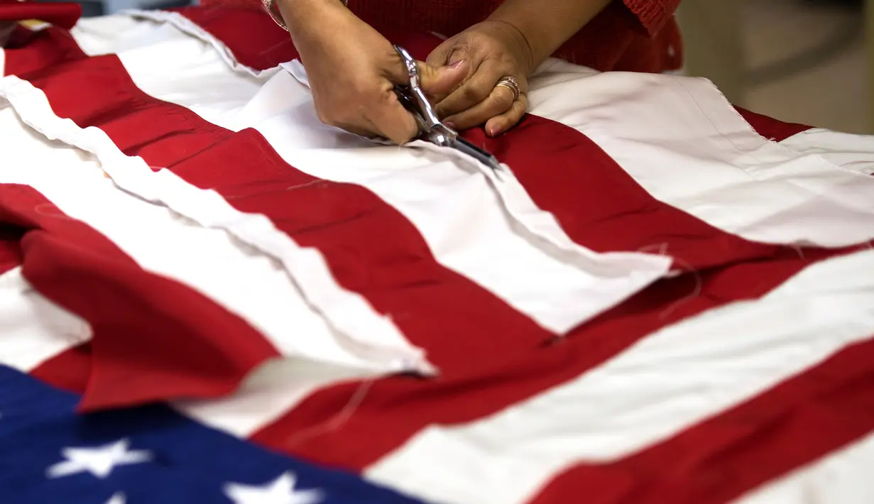 Seorang pekerja menyelesaikan pembuatan Bendera Amerika Serikat yang akan digunakan untuk upacara pelantikan presiden baru Amerika Serikat Donald Trump, Alexandria Virginia, AS (10/1). (AFP/Andrew Caballero Reynolds)