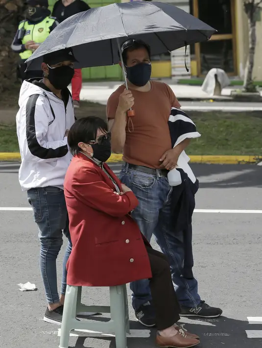 Kerabat menemani dan anggota keluarga lanjut usia saat dia mengantre untuk disuntik vaksin Covid-19 di luar pusat vaksinasi Social Security Institute di Quito, Ekuador, Kamis (6/5/2021). Para lansia dan pendampingnya menunggu berjam-jam untuk divaksinasi. (AP Photo/Dolores Ochoa)