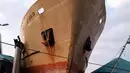 Penduduk desa melihat sebuah kapal yang tersapu hingga ke darat oleh tsunami di Kota Palu di Sulawesi Tengah, Sabtu (29/9). Gelombang tsunami setinggi 3 meter yang menerjang Palu terjadi setelah gempa bumi mengguncang Palu dan Donggala. (AP/Rio Mario)