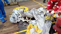 Petugas memeriksa puing dari pesawat Lion Air bernomor penerbangan JT-610 rute Jakarta-Pangkalpinang yang jatuh di perairan Tanjung Karawang, Jawa Barat, Senin (29/10). (HO/NATIONAL DISASTER MITIGATION AGENCY/PERTAMINA HULU ENERGY / AFP)