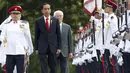 Presiden Jokowi (tengah) berjalan ditemani Presiden Singapura, Tony Tan (kanan) saat menginspeksi barisan tentara dalam seremonial penyambutan di Istana Kepresidenan Singapura, Selasa, (28/7/2015).Jokowi membawa misi ekonomi (REUTERS/Edgar Su)