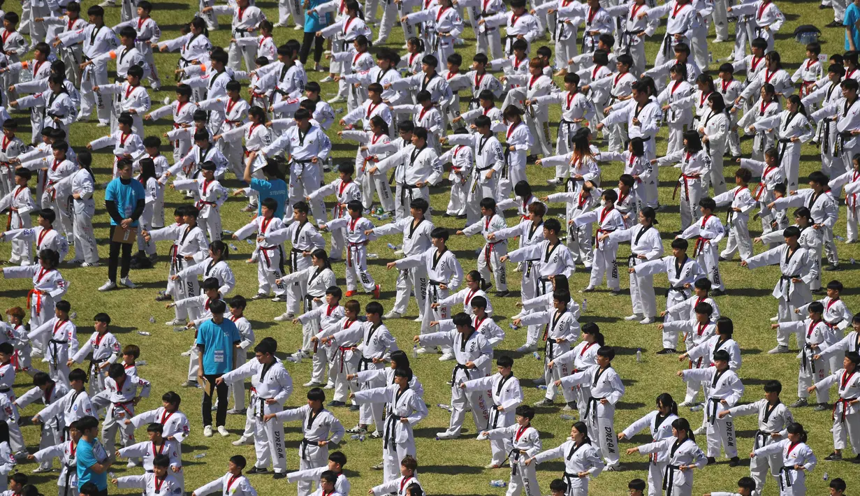 Peserta unjuk kebolehan Taekwondo di luar gedung Majelis Nasional Korea Selatan di Seoul (21/5). Acara ini melibatkan sekitar 10.000 peserta termasuk anak-anak yang bertujuan memperkenalkan taekwondo sebagai seni bela diri. (AFP Photo/Jung Yeon-je)