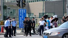 Personel keamanan China berdiri di luar kedutaan besar Amerika Serikat setelah laporan ledakan di Beijing, Kamis (26/7). Ledakan disebut berada dekat tempat warga China mengantre untuk masuk ke Kedubes AS untuk mengurus visa. (AP/Mark Schiefelbein)
