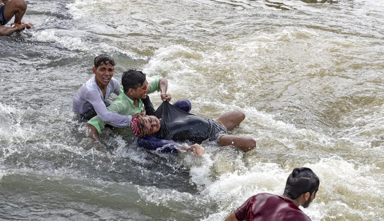 Orang-orang bermain di perairan Air Terjun Rajdari pada hari musim panas yang terik di distrik Chandauli, negara bagian Uttar Pradesh, India (28/6/2021).  Air Terjun Rajdari adalah tempat piknik yang populer bagi orang-orang di sekitar area tersebut pada musim panas. (AP Photo/Rajesh Kumar Singh)