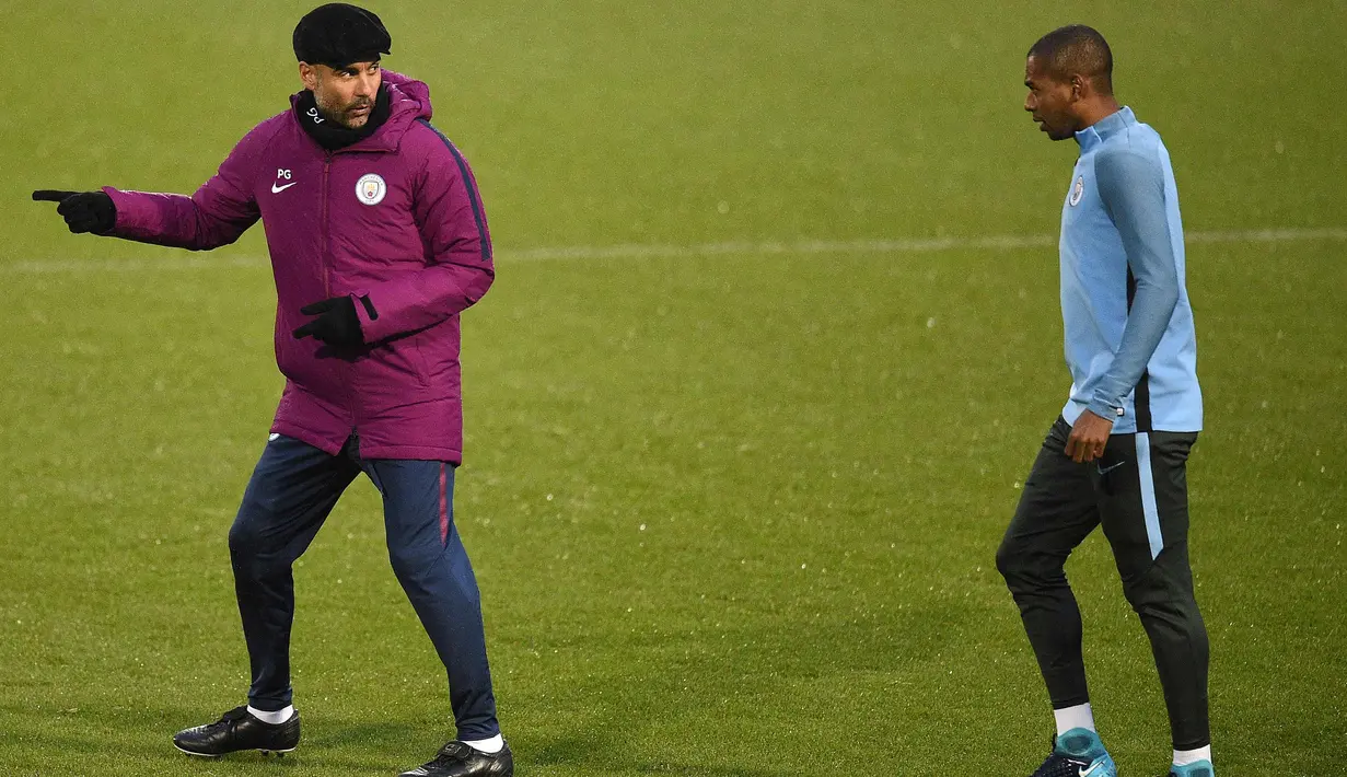Pelatih Manchester City, Pep Guardiola berdiskusi dengan gelandang Fernandinho saat latihan jelang menghadapi Feyenoord pada Grup F Liga Champions di Manchester, Inggris (20/11). (AFP Photo/Oli Scarff)