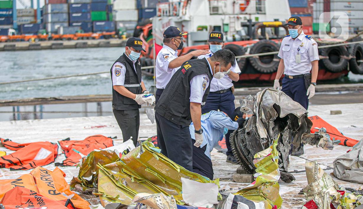 Petugas KNKT memeriksa bagian turbin pesawat Sriwijaya Air dihari kelima yang jatuh di perairan Pulau Seribu, di Dermaga JICT, Jakarta,  Rabu (13/1/2021). Pesawat Sriwijaya Air SJ 182 rute Jakarta-Pontianak  jatuh di perairan Kepulauan Seribu Sabtu (9/1) petang. (Liputan6.com/Faizal Fanani)