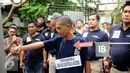 Salah satu tersangka penyerangan polisi hingga tewas melakukan reka ulang kejadian di kawasan Berlan, Jakarta, Jumat (19/2/2016). Tersangka memeragakan 54 adegan penyerangan terhadap dua anggota polisi. (Liputan6.com/Helmi Fithriansyah)