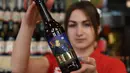Karyawan menunjukkan botol bir bergambar Presiden AS Donald Trump di perusahaan bir Pravada di Lviv, Ukraina, 20 Mei 2017. Perusahaan itu menciptakan bir yang dijuluki sebagai 'Trump. The President of the Divided States of America'. (Yuri DYACHYSHYN/AFP)