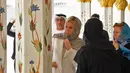 Istri Presiden Prancis, Brigitte Macron melihat desain Masjid Sheik Zayed di Abu Dhabi, Uni Emirate Arab, Kamis (9/11). Di masjid tersebut, Brigitte terlihat mengenakan penutup kepala bermotif leopard dan melepas sepatu. (Giuseppe CACACE / AFP)