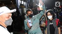 Menteri Pariwisata dan Ekonomi Kreatif Sandiaga Uno (tengah) menunjukan minuman yang telah dipesan melalui pembayaran cashless QRIS GoPay di Food Truck Goes to Mandalika, Jakarta (13/03/2022). (Liputan6.com/HO/Ading)