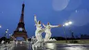 Dua orang atlet Mesir melompat di depan menara Eiffel saat acara pembukaan Olimpiade 2024 di Paris, Sabtu (27/7/2024).  (AP Photo/Andy Wong)