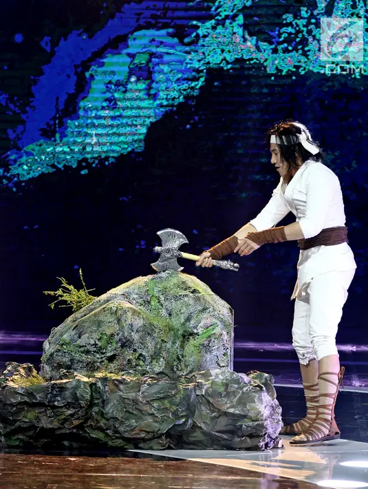 Pemeran 'Wiro Sableng', Vino Bastian mencabut kapak yang tertancap di batu dalam acara IBOMA 2018 di STUDIO 6 EMTEK CITY, Jakarta, Jumat (23/3). (Liputan6.com/Herman Zakharia)