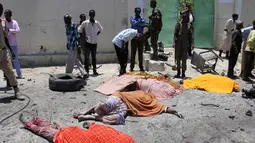 Sejumlah mayat tergeletak akibat serangan bom mobil di sebuah restoran di Mogadishu, Somalia, Rabu (5/4). Ledakan bom mobil tersebut telah menewaskan sejumlah orang. (AP Photo / Farah Abdi Warsameh)