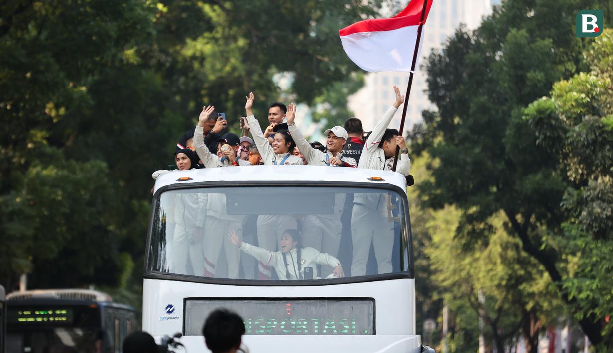 Sejumlah atlet dan ofisial Kontingen Indonesia pada Olimpiade Paris 2024, termasuk peraih medali emas, Veddriq Leonardo dan Rizki Juniansyah serta peraih medali perunggu, Gregoria Mariska Tunjung mengikuti pawai dengan menaiki bus tingkat terbuka Transjakarta menuju Istana Negara, Jakarta Pusat, Kamis (15/8/2024). (Bola.com/Abdul Aziz)