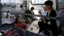 Sebuah keluarga menikmati makanan di dalam mobil mereka di kota Mashiki, prefektur Kumamoto, Jepang, 17 April 2016. Gempa yang terjadi pada Kamis (14/4) malam membuat banyak warga lebih memilih mengungsi dan tidur di mobil mereka sendiri. (Reuters/Kyodo)