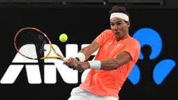 Petenis Spanyol, Rafael Nadal mengembalikan bola ke arah petenis Austria, Dominic Thiem dalam pertandingan tenis eksibisi di Adelaide, Jumat (29/1/2021) menjelang berlangsungnya Turnamen Tenis Australia Open. Rafael Nadal menang 7-6, 6-4 atas Dominic Thiem. (AFP/Michael Errey)