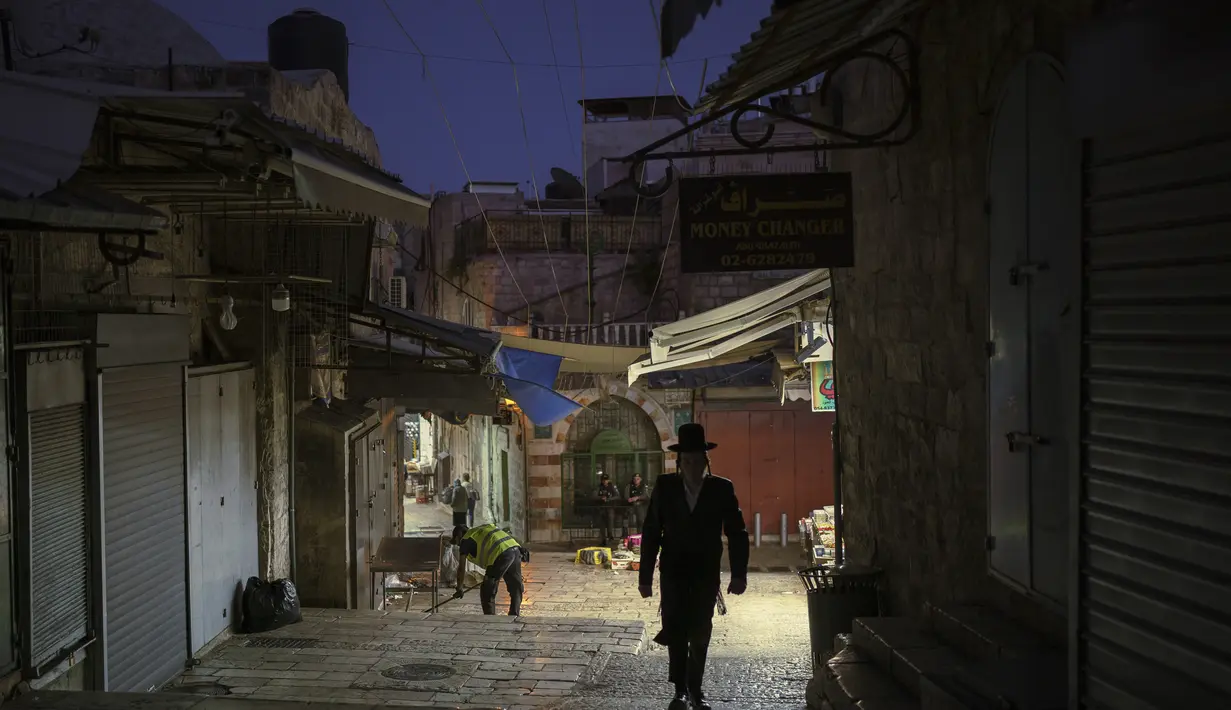 Seorang pria berjalan di malam hari di Kota Tua Yerusalem beberapa hari setelah gencatan senjata tercapai dalam perang 11 hari antara penguasa Hamas di Gaza dan Israel, Sabtu (29/5/2021).  (AP Photo/Felipe Dana)