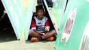Seorang anak berteduh saat mengikuti Milo Football Clinic di Lapangan Sepak Bola Pertamina, Simprug, Jakarta, Minggu (24/4/2016). (Bola.com/Nicklas Hanoatubun)
