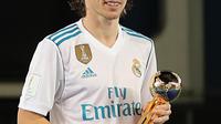Gelandang Real Madrid, Luka Modric tersenyum saat berpose dengan trofi bola emas Piala Dunia Antarklub 2017 distadion Zayed Sports City,Abu Dhabi, Uni Emirat Arab, (16/12). Modric menjadi man of the match. (AFP Photo/Karim Sahib)