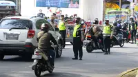 Polantas menghentikan kendaraan saat Operasi Gabungan Tertib Administrasi Kendaraan Bermotor (KBM) Kendaraan Tidak Mendaftar Ulang (KTMDU) 2022 di Jembatan Panus, Depok, Kamis (9/6/2022). Ratusan kendaraan bermotor yang belum membayar pajak atau kendaraan tidak melakukan daftar ulang (KTMDU) terjaring dalam razia yang dilakukan Sistem Administrasi Manunggal Satu Atap (Samsat) Depok ini. (merdeka.com/Arie Basuki)