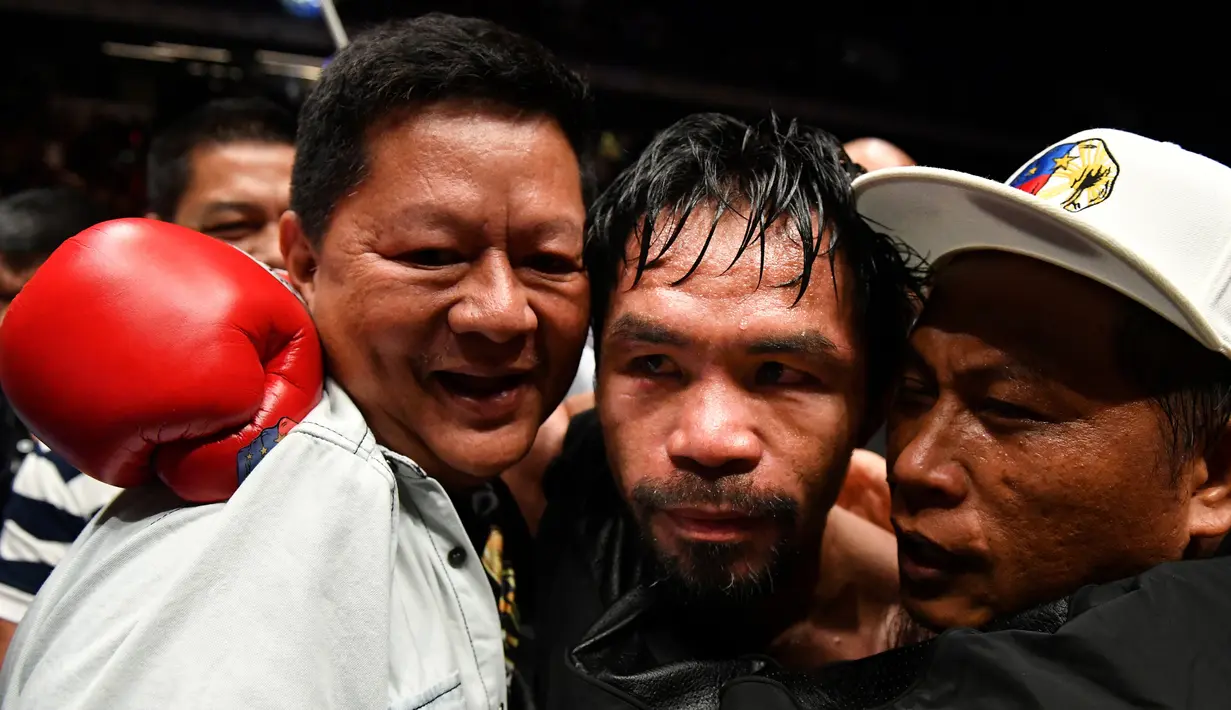 Petinju Filipina Manny Pacquiao merayakan kemenangannya usai melawan petinju Argentina, Lucas Matthysse pada kelas welter versi WBA di Axiata Arena di Kuala Lumpur, Malaysia (15/7). Pacquiao menang KO atas Matthysse di Ronde ke 7. (AFP Photo/Mohd Rasfan)