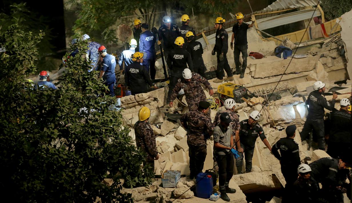 Tim penyelamat Pertahanan Sipil Yordania melakukan operasi pencarian terhadap penghuni sebuah bangunan empat lantai yang runtuh, di Amman, Yordania, Selasa (13/9/2022). Direktorat Keamanan Masyarakat Yordania mengonfirmasi jumlah korban tewas mauun terluka dalam insiden yang terjadi dikawasan Jabal al-Weibdeh. (AP Photo/Raad Adayleh)