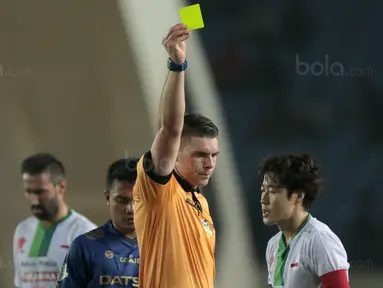 Wasit Evan Shaun Robert memberikan kartu kuning kepada pemain PS TNI, Hong Soon-hak saat laga melawan Persib Bandung pada lanjutan Liga 1 2017 di Stadion Si Jalak Harupat, Sabtu (05/8/2017). (Bola.com/Nicklas Hanoatubun)