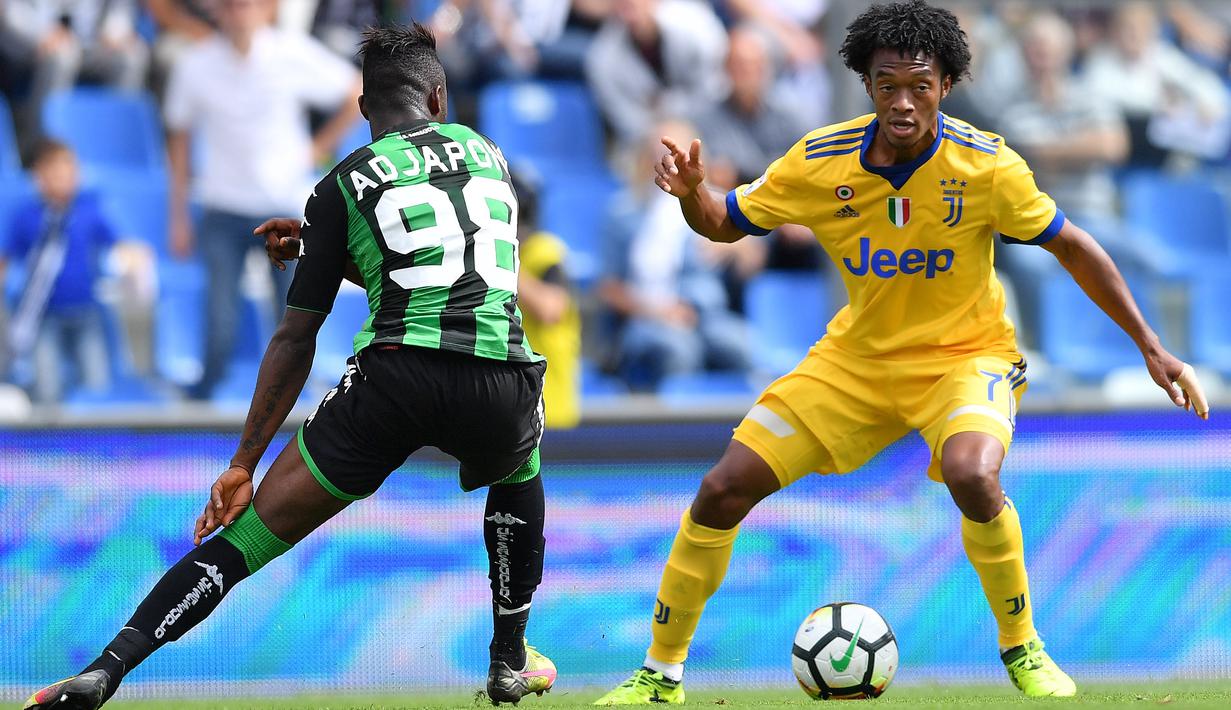 Pemain Sassuolo, Claud Adjapong (kiri) mencoba merebut bola dari pemain Juventus, Juan Cuadrado pada lanjutan Serie A di  Stadio Citta del Tricolore, Reggio Emilia, Italia (17/9/2017). Juventus menang 3-1. (AFP/Marco Bertorello)