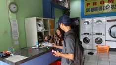 Pekerja melayani pelanggan di toko laundry di Jakarta, Rabu (20/6). Libur lebaran banyak jasa laundry kebanjiran order hingga 100 karena banyaknya para pembatu rumah tangga yang mudik lebaran. (Liputan6.com/Angga Yuniar)