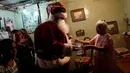 Santa Claus berbincang dengan seorang wanita di kawasan kumuh Petare di Caracas, Venezuela (11/12). (Reuters/Ueslei Marcelino)