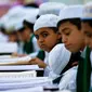 Ekspresi anak-anak muslim saat mengikuti baca Alquran berjemaah selama bulan Ramadan di Masjid Imam Ali Ibn Abi Tholib di Najaf, Irak (2/6). (AFP/Haidar Hamdani)