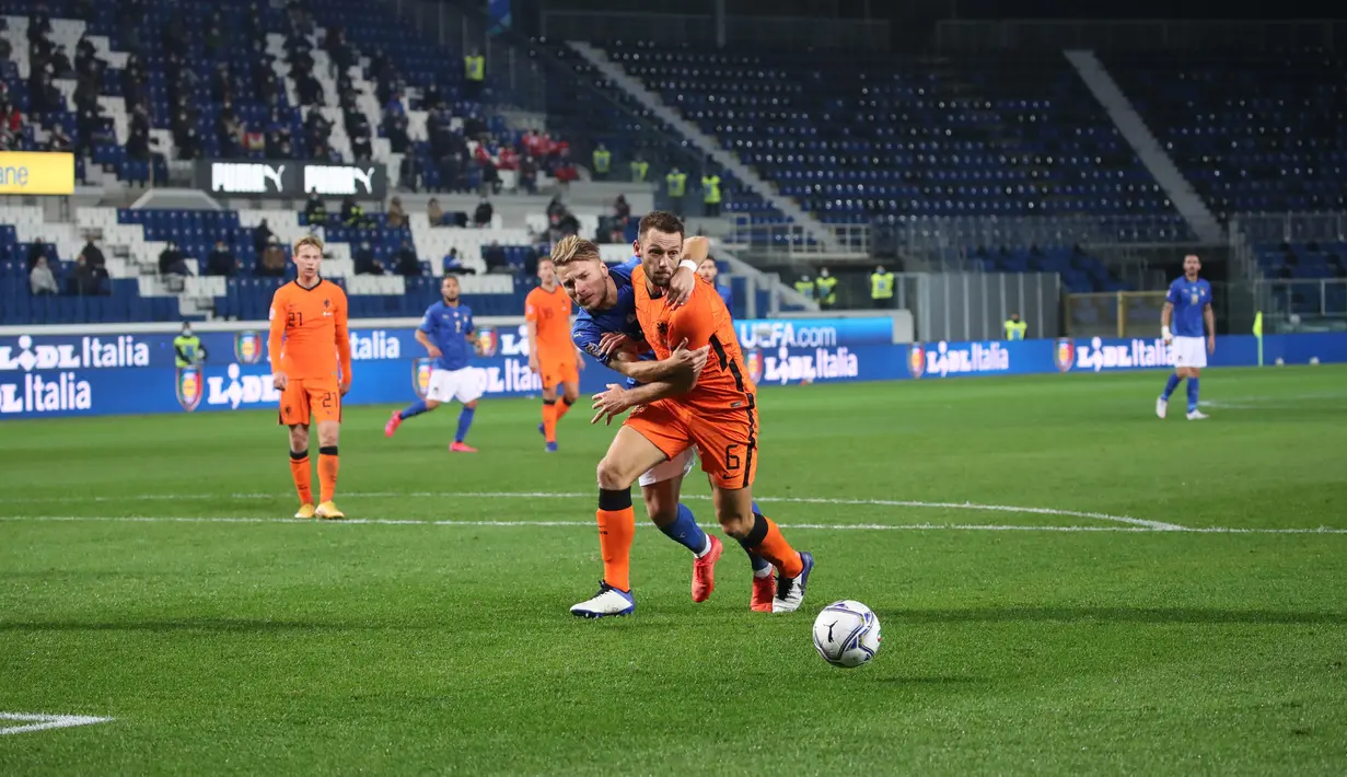 Pemain Italia Ciro Immobile (kiri) berebut bola dengan pemain Belanda Stefan de Vrij (kanan) pada pertandingan UEFA Nations League di Azzurri d'Italia Stadium, Bergamo, Italia, Rabu (14/10/2020). Pertandingan berakhir dengan skor 1-1. (Stefano Nicoli/LaPresse via AP)