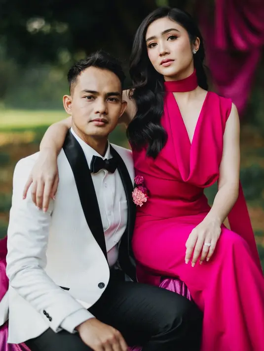 Dengan latar belakang pohon besar yang alami, dekorasi kain beludru berwarna magenta menambah kesan glamor dan klasik pada suasana alam terbuka.  [@terralogical @leurafilm].