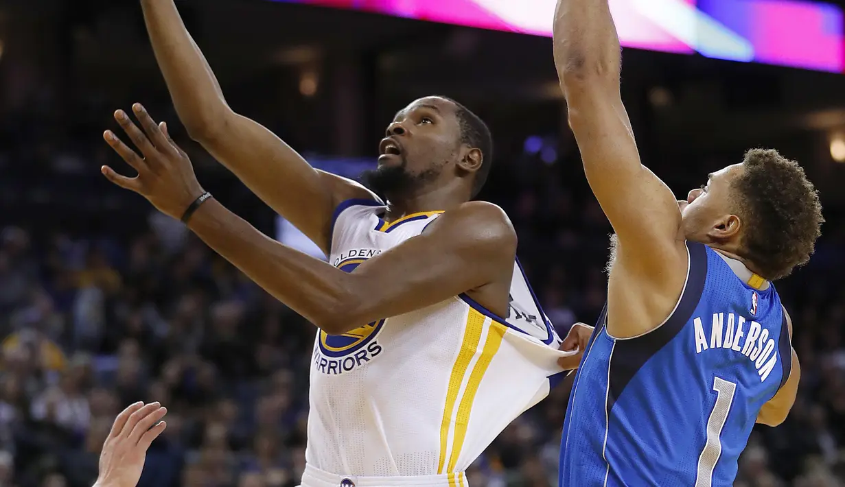 Pemain Warriors, SKevin Durant #35 melakukan layup melewati penjagaan pemain Dallas Mavericks pada laga NBA basketball game  di Oakland, California, (30/12/2016). Warriors menang 108-99. (AP/Tony Avelar)