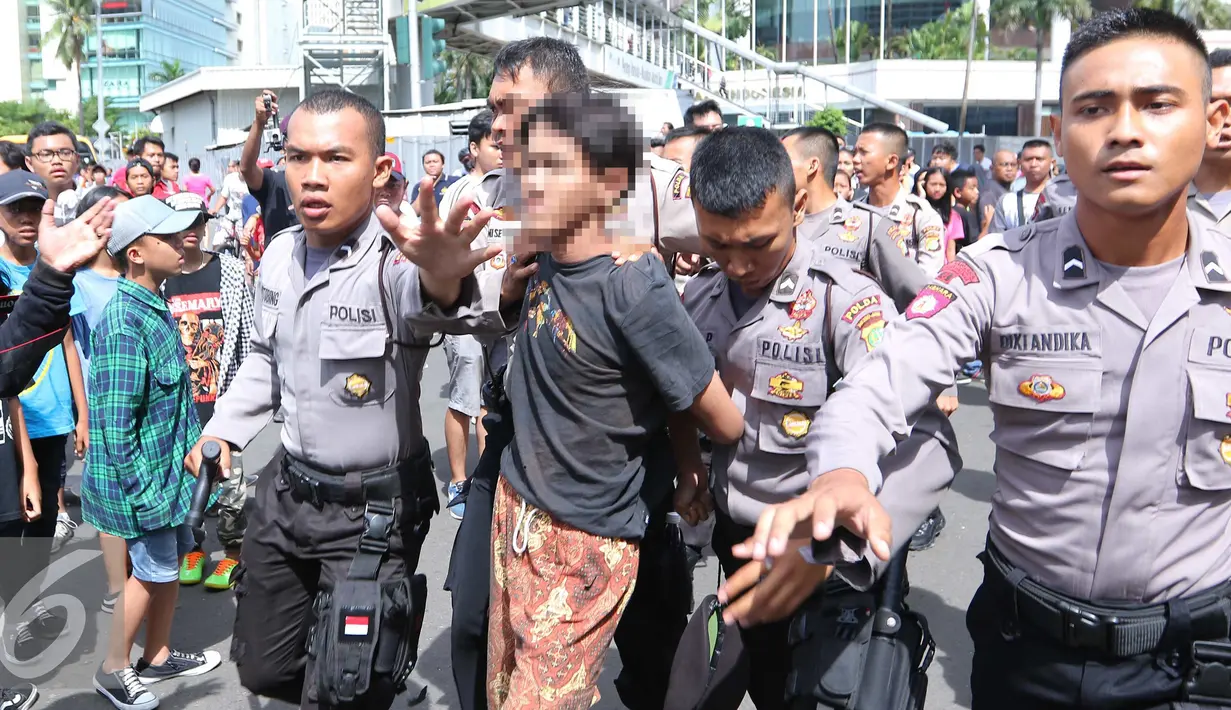 Polisi mengamankan sejumlah remaja saat Car Free Day di Jakarta, Minggu (2/10). Setidaknya empat remaja diamankan petugas karena melakukan tindakan penodongan dan pencopetan. (Liputan6.com/Angga Yuniar)