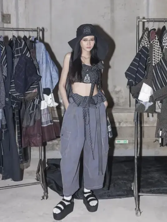 Perpaduan atasan bermotif etnik dengan celana kargo oversized, topi bucket, dan sandal platform, menciptakan gaya streetwear edgy yang penuh karakter. (foto: instagram.com/dsgnsofie)