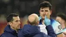 Tim medis memeriksa pemain Inggris, Harry Maguire, setelah terjadi benturan dengan pemain Makedonia Utara dalam duel matchday 10 Kualifikasi Euro 2024 Grup C, Selasa (21/11/2023). (AP Photo/Darko Vojinovic)