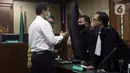 Terdakwa suap penanganan perkara korupsi di Lampung Tengah yang juga mantan Wakil Ketua DPR Azis Syamsuddin (kiri) usai sidang pembacaan putusan di Pengadilan Tipikor Jakarta, Kamis (17/2/2022). Azis Syamsuddin divonis 3 tahun 6 bulan penjara dan denda Rp 250 juta. (Liputan6.com/Helmi Fithriansyah)