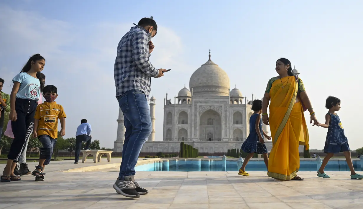 Sejumlah wisatawan mengunjungi Taj Mahal setelah dibuka kembali untuk pengunjung di Agra, Rabu (16/6/2021). Taj Mahal, yang terkenal sebagai ikonik India telah dibuka kembali untuk umum, ketika negara itu mulai melonggarkan pembatasan Covid-19. (Money SHARMA/AFP)