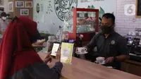 Nasabah memanfaatkan layanan digital bank melalui layanan Mandiri Syariah Mobile di Jakarta, Rabu (8/7/2020). Mandiri Syariah juga mengoptimalkan metode pembayaran digital tanpa uang tunai sebagai upaya untuk mengurangi risiko penyebaran Covid-19 di Era New Normal. (Liputan6.com/Angga Yuniar)