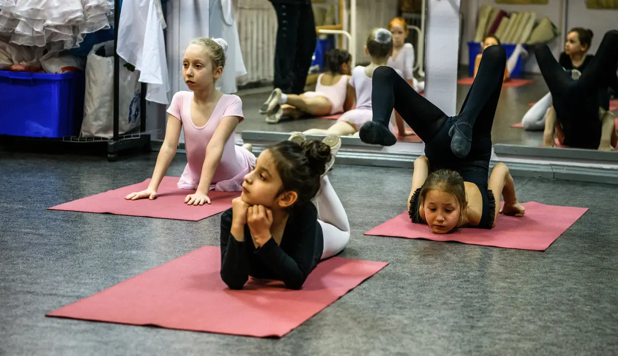 Gadis-gadis kecil mengikuti kelas balet di sebuah studio di Moskow , 22 November 2018. Orang tua dan kakek-nenek duduk di koridor sebuah studio kecil di Moskow utara menunggu anak-anak usia tiga tahun menyelesaikan kelas balet mereka. (Mladen ANTONOV/AFP)