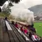 Sebuah kereta uap  melintasi lapangan sepakbola ditengah berlangsungnya pertandingan (101greatgoal)