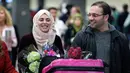 Warga Suriah berjalan bersama istrinya, sekembalinya dari Doha, tiba di Bandara Dulles, Washington, Senin (6/2). Pada Januari, mereka sempat tertahan tidak dapat masuk ke Washington akibat kebijakan imigrasi Donald Trump. (Brendan Smialowski/AFP)