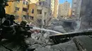 Petugas pemadam kebakaran berupaya memadamkan api di sebuah bangunan setelah serangan udara Israel di distrik Haret Hreik di pinggiran selatan Beirut pada 16 November 2024. (Foto oleh AFP)