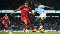Pemain Manchester City, Jeremy Doku (kanan) berebut bola dengan pemain Nottingham Forest, Eric da Silva Moreira pada laga lanjutan Liga Inggris 2024/2025 di Etihad Stadium, Manchester, Inggris, Kamis (05/12/2024). (AP Photo/Martin Rickett)
