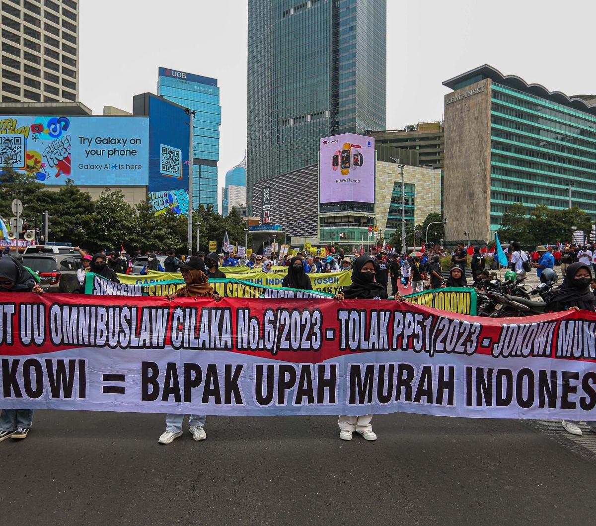 Selain itu, dalam salah satu spanduk yang terpampang, massa buruh menuliskan "Jokowi= Bapak Upah Murah Indonesia".