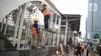 Pekerja menyelesaikan perbaikan Halte Transjakarta yang dibakar pasca aksi unjuk rasa di kawasan Bundara HI, Jakarta, Minggu (11/10/2020). Direktur Utama PT Transportasi Jakarta Sardjono Jhony Tjitrokusumo mengatakan, setidaknya ada 46 halte bus rusak. (Liputan6.com/Faizal Fanani)