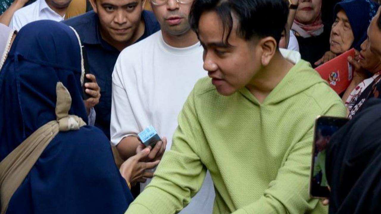 Gibran tampak didampingi artis Raffi Ahmad dalam aksi blusukannya kali ini.&nbsp;Foto: Bay Ismoyo/AFP